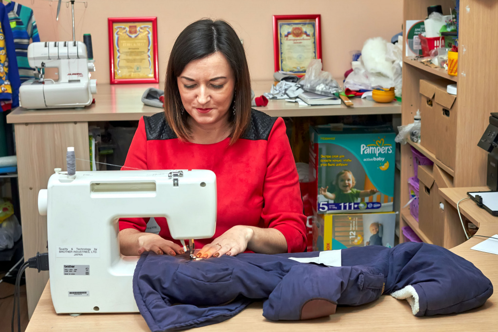 Ирина Глазкова показывает, как можно пришить световозвращающую ленту на куртку. Фото: Вадим Аминов, "Вечерний Краснотурьинск"